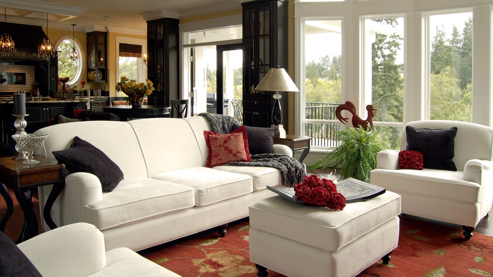 A living room with white furniture and red accents.